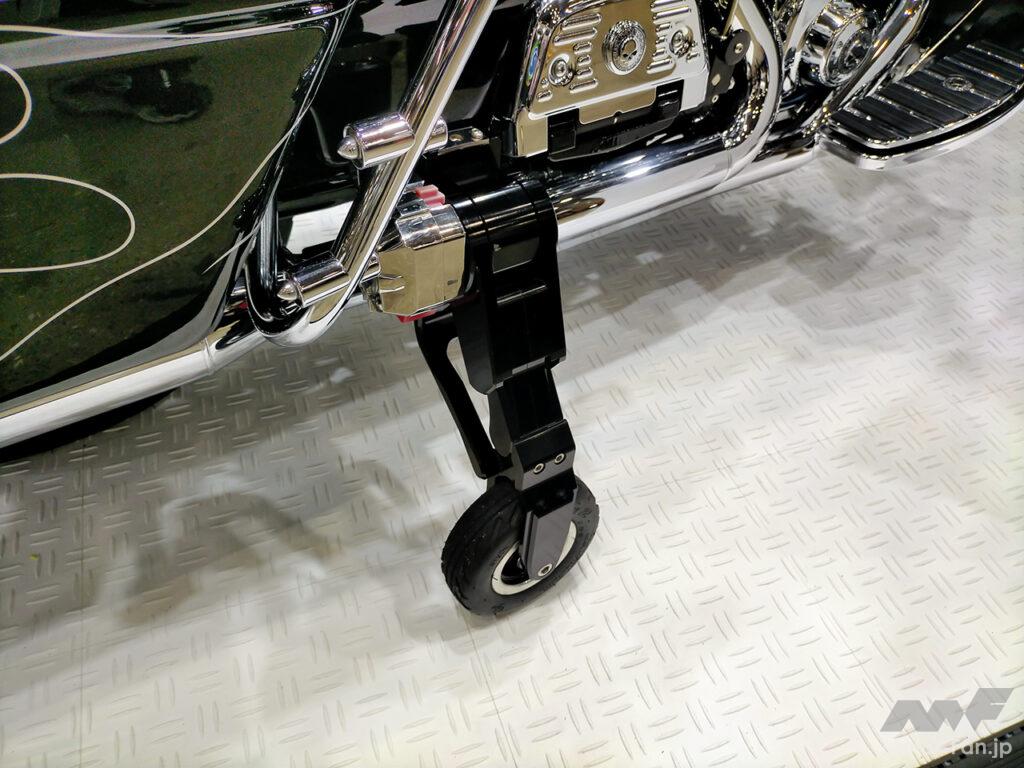「車検対応のバイク用補助輪！　ボタン1つで収納・設置も超スムーズなビッグツアラー用です。｜大阪・東京モーターサイクルショー2023」の2枚目の画像