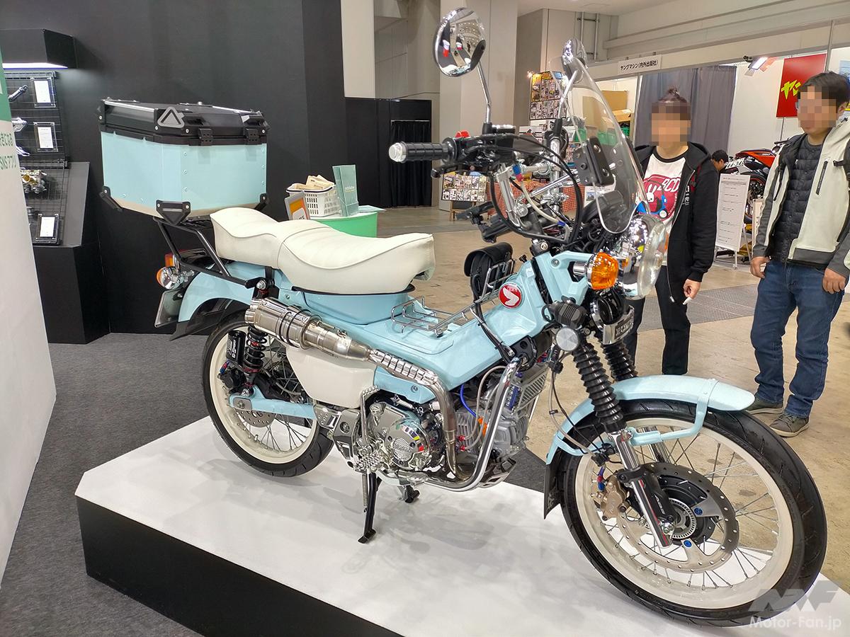 パステルカラーのCT125ハンターカブ、ホワイトリボン風ホイールとの相性も抜群です！  ホワイトのWシートやホイールもセンスが光る｜モーターサイクルショー2024 ｜ Motor-Fan BIKES[モーターファンバイクス]