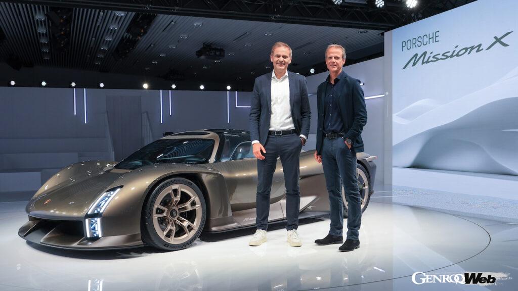 「75 Years of Porsche Sports Cars」を前に「ポルシェ ミッション X」を公開した、 ポルシェAGのオリバー・ブルーメ取締役会会長（左）と、デザイン部門を率いるマイケル・マイケル・マウアー（右）。