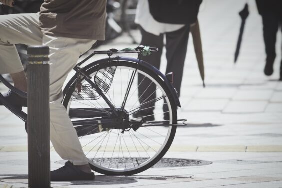 歩道で自転車にまたがる人の写真