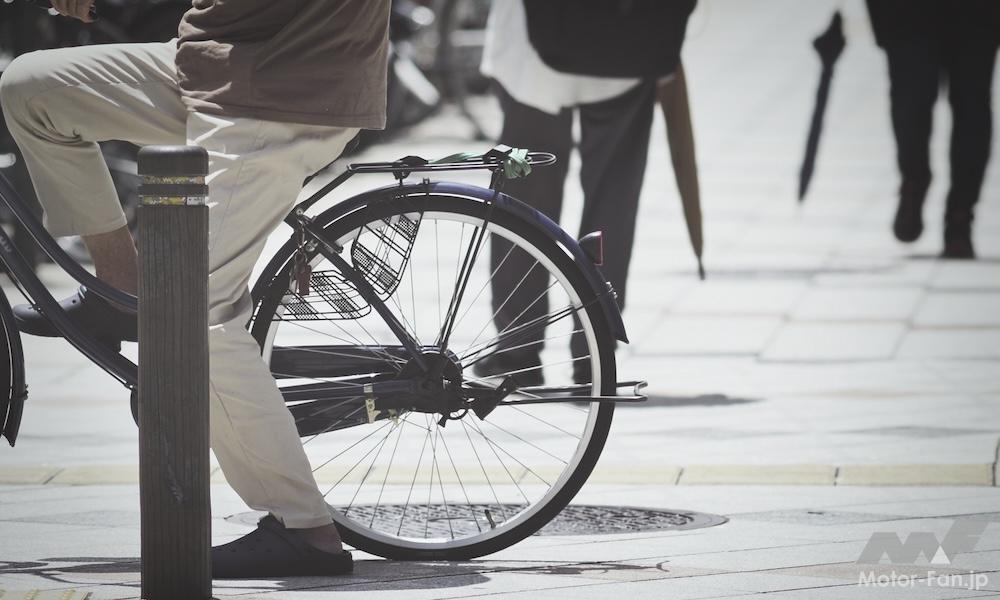 歩道で自転車にまたがる人の写真
