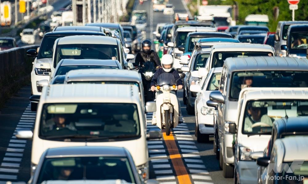 クルマとクルマの間をすり抜けるバイクの写真