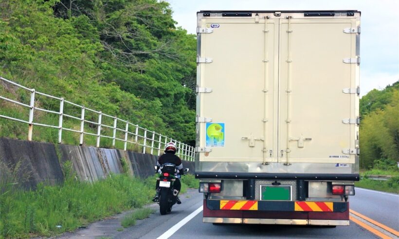 トラックの横をすり抜けようとするバイク