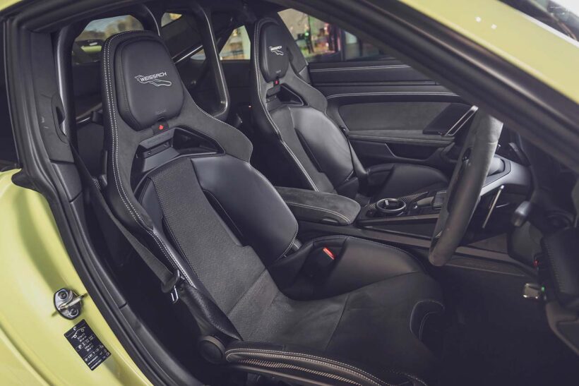 992II世代になりGT3のメーターパネルもフルデジタルに。試乗車は右ハンドルの7速DCT仕様で、オプションのヴァイザッハパッケージ（339万円）、クラブスポーツパッケージ（無償）を装着。フロントリッドやルーフなどがカーボン製になるほか、インテリアは一面バックスキン調の合成皮革でスポーティな装いに。ロールケージや6点式シートベルトも含まれる。エンジンフードはなく、オイルと冷却水の注入口を覆うフタが開くのみだ。