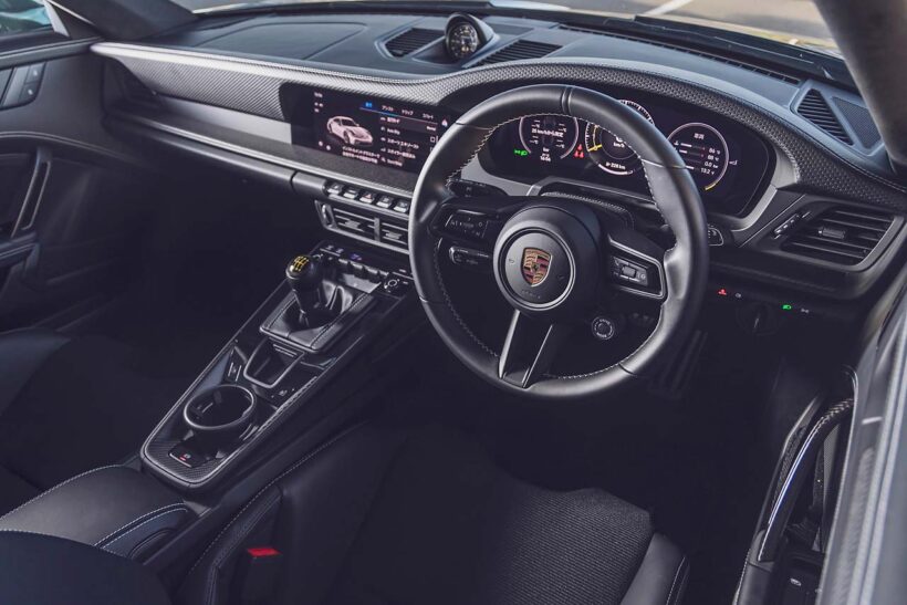 ツーリングパッケージの試乗車は6速MT仕様。エンジンの始動はカレラ系のようなボタン式ではなく、ロータリー式のイグニッションスイッチが残されている。ライトウェイトパッケージ（507.2万円）が装着されており、これを選ぶとルーフやバケットシート、リヤのスタビライザーがカーボン製になるほか、6速MTが911 S/T譲りのショートストロークタイプに。ホイールも9kgの軽量化を実現するマグネシウム製だ。リヤシートは無償オプション。