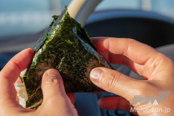 車内でおにぎりを食べる様子