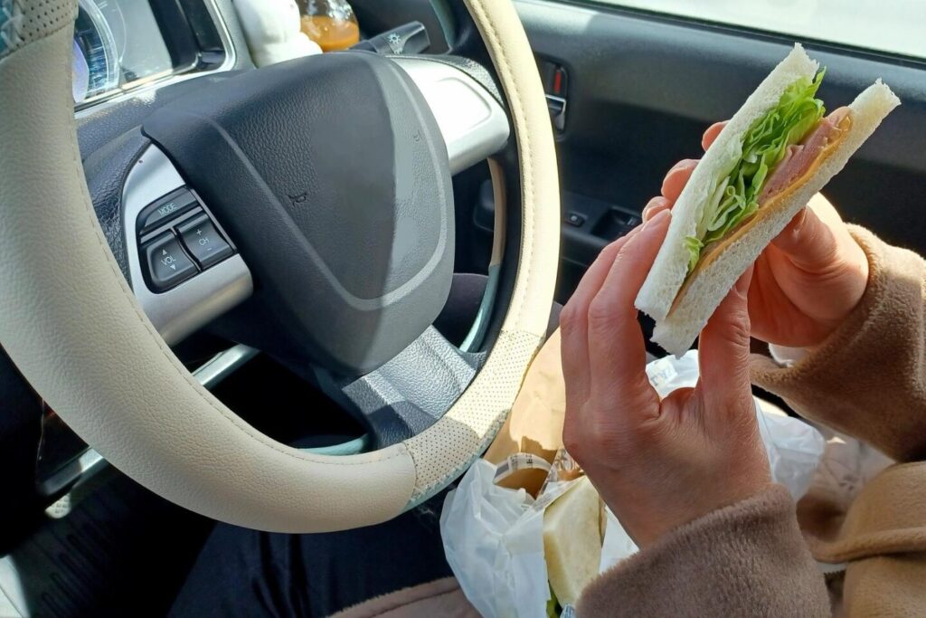 車内でサンドウィッチを食べる様子