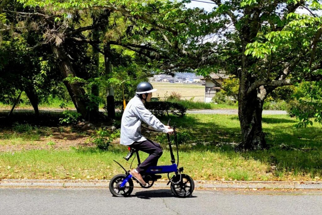 ヘルメットを着用して電動バイクを運転している人