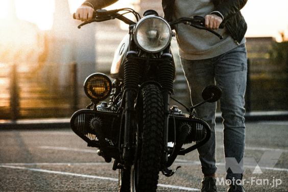 バイクを押し歩きする男性