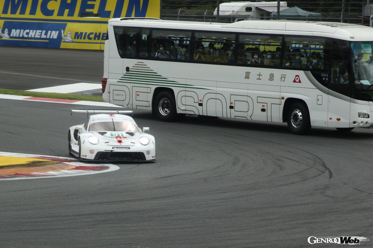 バスの間近を駆け抜けるポルシェ911RSR-19。ドライバー側もサウンドを楽しんで欲しいとあえて接近することもあるという。