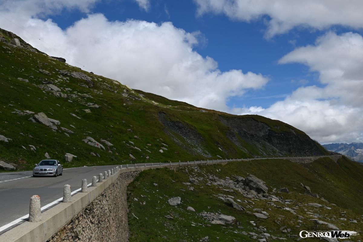 峠の頂上である2436mを示す標識周辺は、記念撮影や休憩をする多くの人々で賑う。