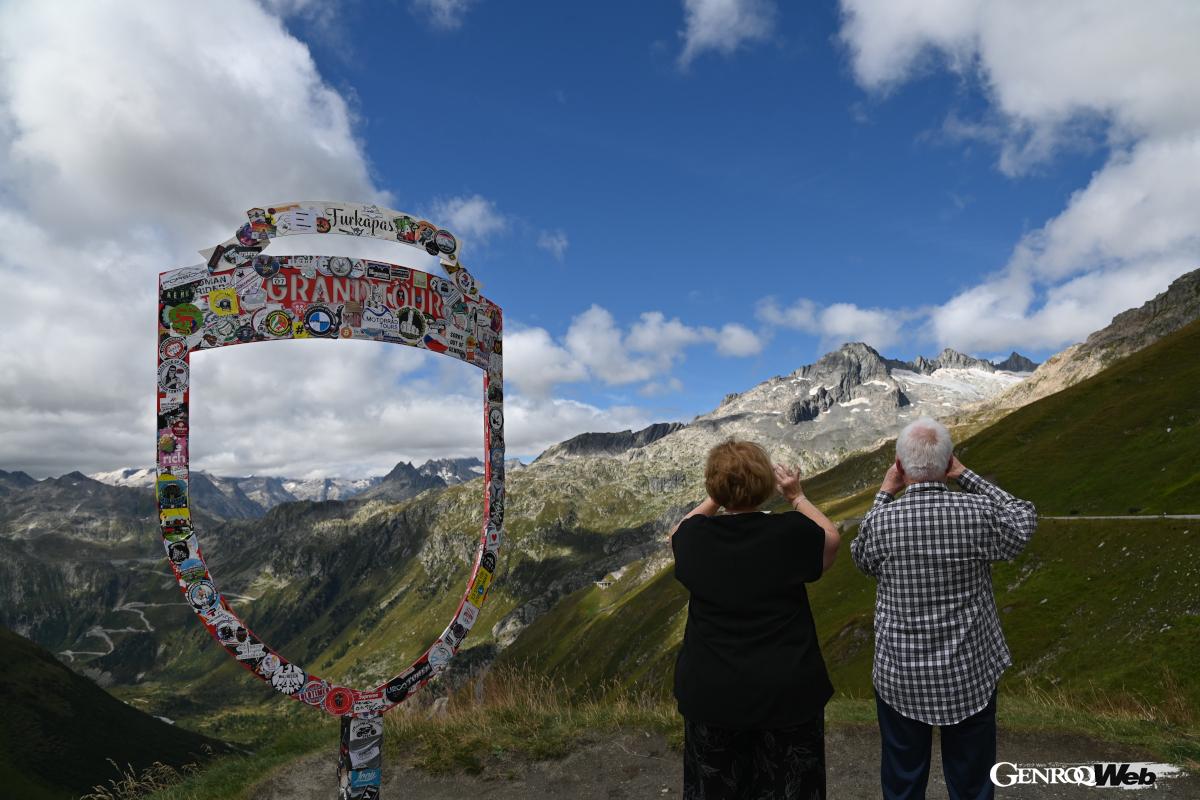 峠の頂上である2436mを示す標識周辺は、記念撮影や休憩をする多くの人々で賑う。