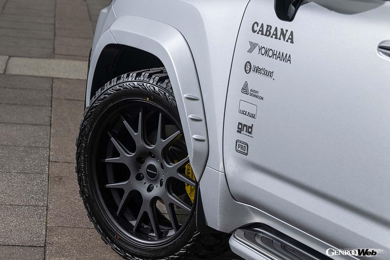 【LX600 EXECUTIVE】LX600標準モデル、エグゼクティブを対象としたプログラム。端正なフロントマスクに加え、片側50mmワイドのオーバーフェンダー、そしてヒッチメンバーの機能を犠牲にしないリヤスポイラー、ボンネットフードのダクトなど、数多くのパーツでアーティシャンスピリッツ流に彩られる。排気系はフルチタンエキゾースト。ホイールはオリジナルの「CORART A7」が用意されているが、これは22インチと24インチを選ぶことができる。