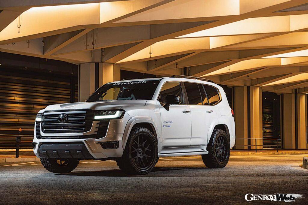 【LAND CRUISER 300 Ver.01】ランクル300をよりオフテイストに引き立てる一例だ。スキッドブロック風のアンダーカバーに、オフロードタイヤ（ジオランダーM/T）を組み合わせるだけで、ランクル300がその本性を露わにするかのように、よりマッシブに見違える。バンパーガーニッシュ、リヤゲートスポイラーなどディテールも凝っている。この個体はオーバーフェンダー片側＋30mmワイドになるが、左の＋50mmワイドフェンダーを組み合わせることもできる。