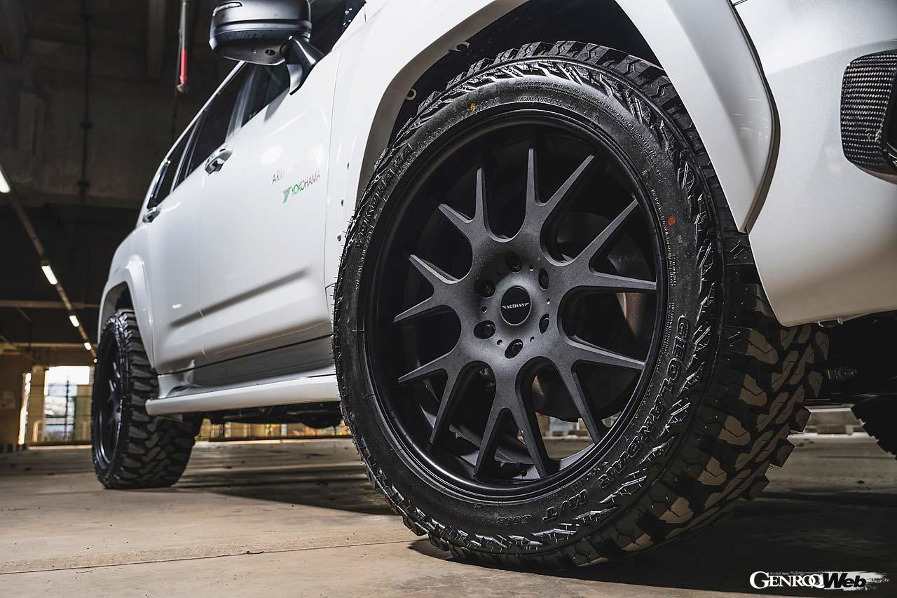 【LAND CRUISER 300 Ver.01】ランクル300をよりオフテイストに引き立てる一例だ。スキッドブロック風のアンダーカバーに、オフロードタイヤ（ジオランダーM/T）を組み合わせるだけで、ランクル300がその本性を露わにするかのように、よりマッシブに見違える。バンパーガーニッシュ、リヤゲートスポイラーなどディテールも凝っている。この個体はオーバーフェンダー片側＋30mmワイドになるが、左の＋50mmワイドフェンダーを組み合わせることもできる。