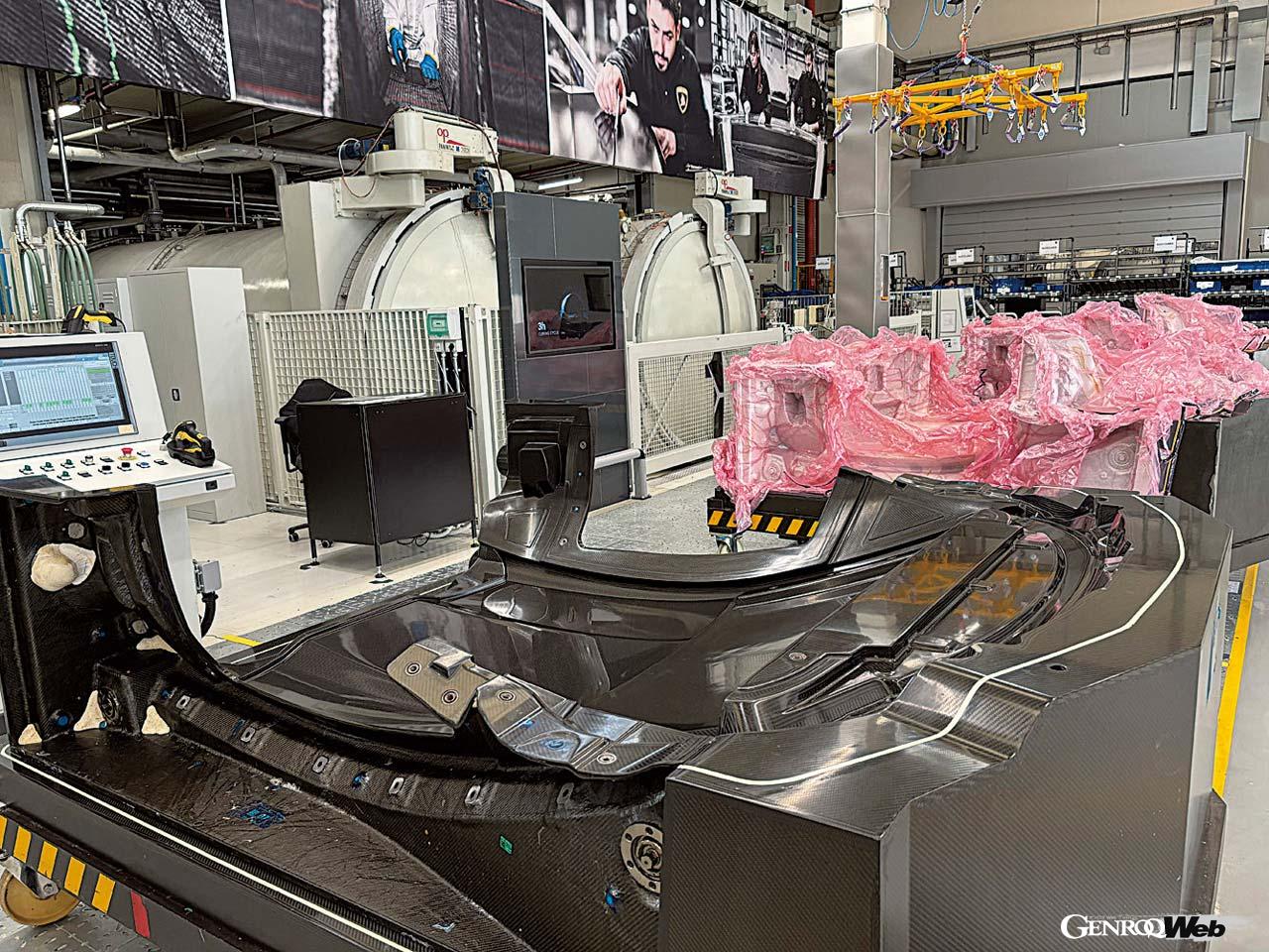 奥に見えるのがカーボンを焼くオーブン。モノコックを加熱するので、相当大きいサイズが必要なのだ。赤いビニールに入ったものが型と一緒に真空状態にされたカーボンの原型。