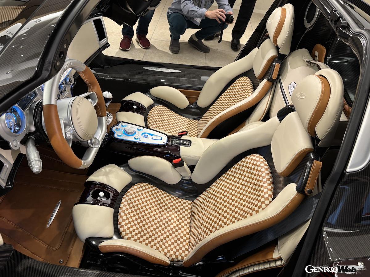 エレガントなデザインのカーボン製シート。背後に収まる専用のバッグの他に、ヘッドレストにかけられるジャケットケースも備わる。