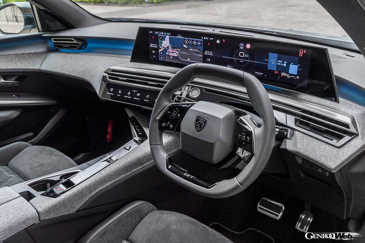 ステアリングの上から見るモニターは何と21インチ。変形ステアリングの操作性は悪くないが、グリップはかなり太い。